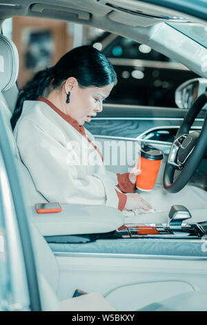 Verwirrt Frau weg Wischen Sie verschütteten Kaffee. Stockfoto