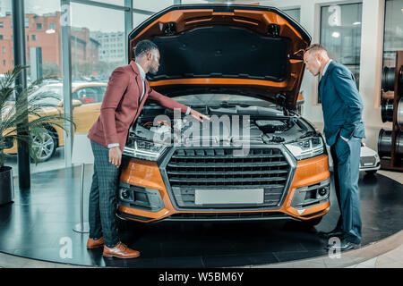 Mann erkunden das Auto unter der capote. Stockfoto