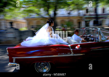 Braut Fahrten entlang der Straße von Havanna, Kuba in eine klassische Wandelanleihe an ihrem Hochzeitstag. Stockfoto