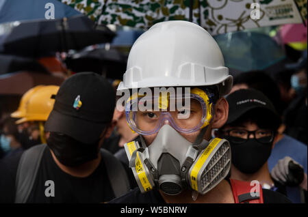 Anti Regierung Demonstranten gesehen mit Gasmasken und Sonnenschirmen ausgestattet, um sich vor möglichen Gas und Pfefferspray Nutzung Tränengas durch die Polizei während der Demonstration zu schützen. Tausende von demonstrant weiterhin ihren wöchentlichen Protest gegen die Regierung fordert die Regierung die Auslieferung Rechnung vollständig zu Rückzug und eine unabhängige Kommission in die Fragen der Polizei Einsatz unverhältnismäßiger Gewalt gegen Demonstranten zu schauen und die Verknüpfung mit lokalen Bandenmitglieder Demonstranten in der vergangenen Woche in Angriff zu nehmen. Der Protest fand im Yuen Long Bezirk, wo die Demonstranten brutal Attacke waren Stockfoto