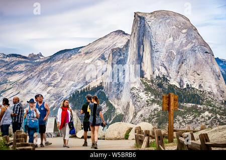 Juni 27, 2019 Yosemite Nationalpark/CA/USA - unbekannter Menschen besuchen Glacier Point; Half Dome im Hintergrund sichtbar Stockfoto