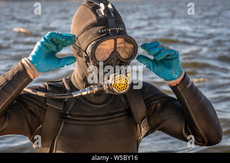 Eine wilde Oyster Diver bereitet und prüft seine Ausrüstung vor dem Tauchgang, Wittman, Maryland. Stockfoto