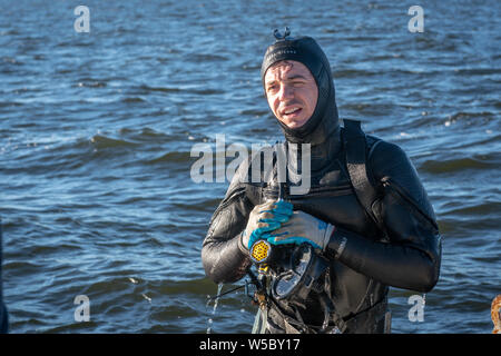 Eine wilde Oyster Diver bereitet und prüft seine Ausrüstung vor dem Tauchgang, Wittman, Maryland. Stockfoto