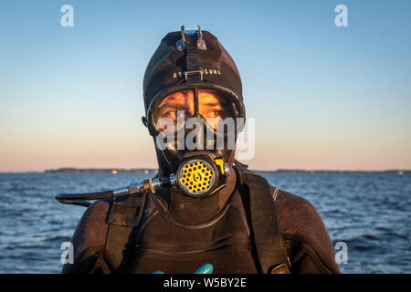 Eine wilde Oyster Diver bereitet und prüft seine Ausrüstung vor dem Tauchgang, Wittman, Maryland. Stockfoto