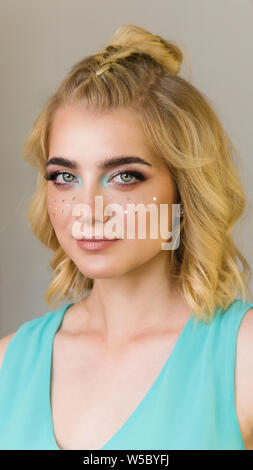 Portrait von cute girl mit Glitzer auf die Wangen. Attraktive charmante Frau mit großen Locken. Fashion, Beauty, Abend Make-up, Frisur, schöne, specta Stockfoto