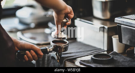 Nahaufnahme des Weiblichen barista Hand schleifen Kaffee mit der Fräse Maschine im Cafe Stockfoto