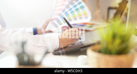 Freelancer retoucher Frau arbeitet auf dem Desktop Computer mit Bildbearbeitung Tablet im Studio office Stockfoto