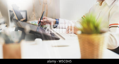 Jungen attraktiven weiblichen Freiberufler in ihr Komfort arbeiten Arbeitsbereich mit Grafiktablett Stockfoto