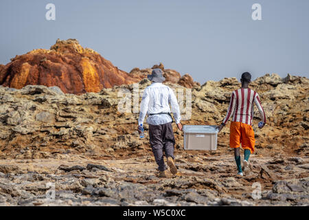 Zwei Forscher, die eine Box von Proben, Dallol hydrothermalen Hot Springs in der danakil Depression an der Afar Dreieck, Äthiopien Stockfoto