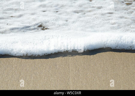 Nahaufnahme, Detail, Schaum und Blasen von abgebrannten Wave waschen über Meer Sand, abstrakt, Hintergrund Stockfoto