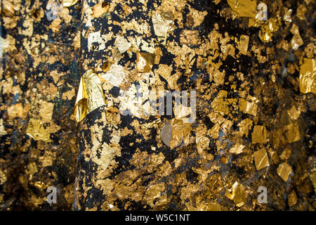 Golden Leaf mit Klebeband auf der Buddha Statue Stockfoto