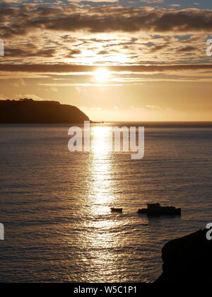 Sonne hinter Mana Island, an einem ruhigen Winter - Fischerboot im Vordergrund. Foto von titahi Bay, Wellington, New Ze genommen Stockfoto