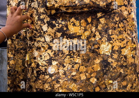 Golden Leaf mit Klebeband auf der Buddha Statue Stockfoto