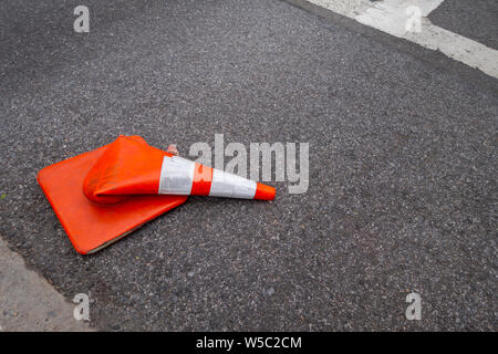 Weißen retroreflektierenden Streifen orange Kegel durch ein Auto auf der Straße Asphalt zerquetscht Stockfoto