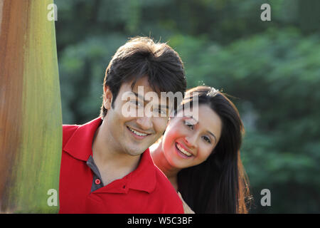 Paar guckt hinter dem Baum hinaus Stockfoto