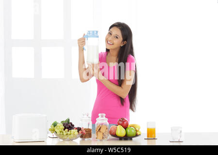 Porträt einer Frau hält einen Krug Milch und lächelnd Stockfoto