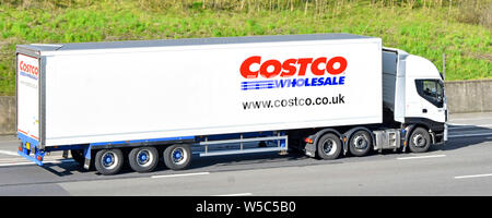 Seitenansicht White Supply Chain Store Delivery LKW & Costco Wholesale Trailer, der den Markennamen und das Logo des Unternehmens anwirbt Fahren Sie auf der britischen Autobahn Stockfoto