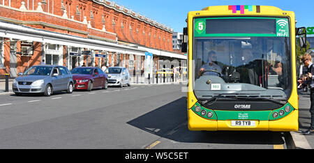 Die Fluggäste gelben Busse Optare single Decker öffentliche Verkehrsmittel Bus Service an der Haltestelle außerhalb Bournemouth Bahn Bahnhof Dorset England UK Stockfoto