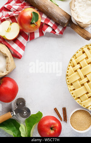 Die Apfelkuchen mit Gitter oben. Raw ungebackene Apfelkuchen mit Werkzeuge und Zutaten zum Kochen. Rahmen Hintergrund mit kopieren. Stockfoto