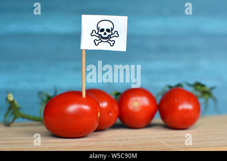 Konzept für den Einsatz gefährlicher Pestizide in der Landwirtschaft Lebensmittel mit roten Tomaten und toxische Warnschild Stockfoto