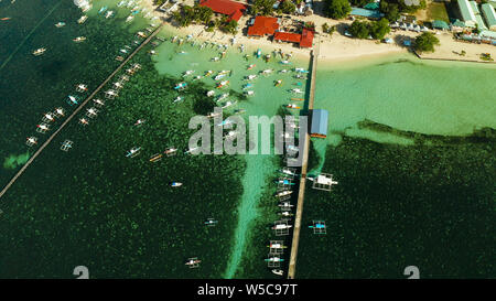 Stadt Allgemeine Luna an der Küste von Siargao mit einem Pier, ein Hafen und touristische Boote bei Sonnenaufgang, Luftbild. Sommer und Reisen Urlaub Konzept. Stockfoto