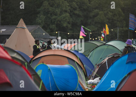 WOMAD-Festival, Charlton Park, Wiltshire, UK. 28. Juli 2019. Am frühen Sonntagmorgen Szenen bei WOMAD, zwischen 05:30-06:30 mit nächtlichen Partygängern bleiben bis in die frühen Stunden, Nachtschicht Sicherheit und Arbeiter sowie der Frühaufsteher, die Warteschlangen dusche Beat. Credit: Francesca Moore/Alamy leben Nachrichten Stockfoto