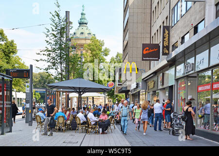 Mannheim, Deutschland - Juli 2019: Menschen zu Fuß durch die Innenstadt von Mannheim mit verschiedenen Geschäften und Cafés im Freien an einem warmen Sommertag Stockfoto