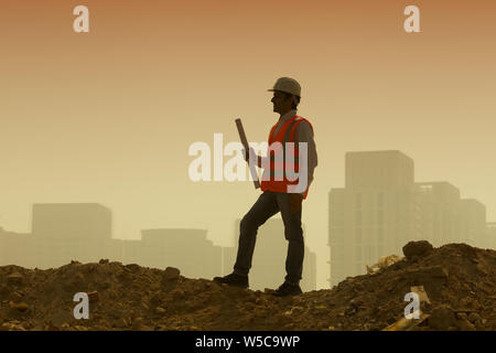 Architekt holding Blueprint auf der Baustelle Stockfoto