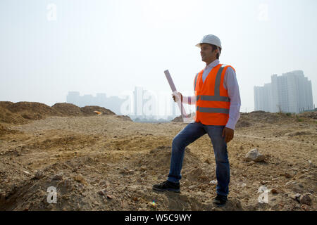 Architekt holding Blueprint auf der Baustelle Stockfoto