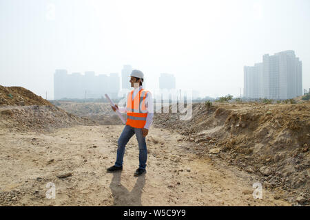 Architekt holding Blueprint auf der Baustelle Stockfoto