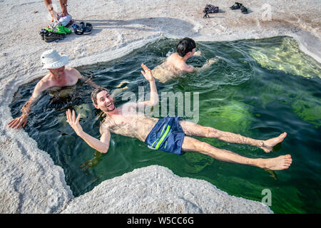 Touristen entspannen im Wasser des Sees Karum, durch ein Loch im Salzsee sichtbar, Danakil Depression, Äthiopien. Stockfoto