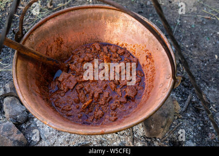 Die köstlichen ungarischen Gulasch in einem Kessel gemacht im Freien am Lagerfeuer Stockfoto