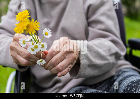 In der Nähe Bild von älteren Menschen die Hände schütteln Holding Blumenstrauß Stockfoto