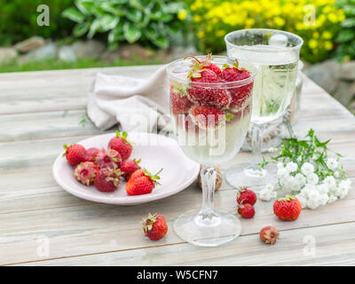 Sekt und Erdbeeren. Sommer Zusammensetzung auf einer hölzernen Tisch. Stockfoto