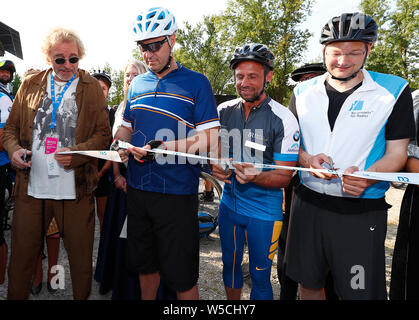 Bad Staffelstein, Deutschland. 28. Juli 2019. Entertainer Thomas Gottschalk (L-R), Markus Söder (CSU), Ministerpräsident des Freistaates Bayern, Thorsten Glauber (Freie Wähler), Staatsminister für Umwelt und Verbraucherschutz, und Hans Reichhart (CSU), Staatsminister für Wohnungsbau, Bau und Verkehr, schneiden Sie ein Band bei der Eröffnung der 30. BR-Radltour. Credit: Peter Kolb/dpa/Alamy leben Nachrichten Stockfoto