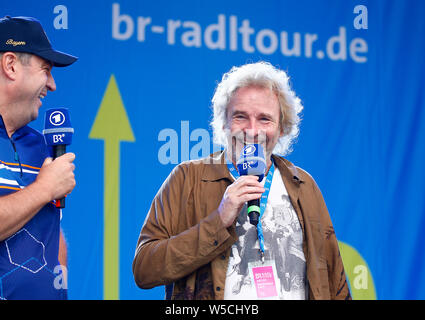 Bad Staffelstein, Deutschland. 28. Juli 2019. Markus Söder (CSU, l), Ministerpräsident des Freistaates Bayern, steht neben Thomas Gottschalk bei der Eröffnung der 30. BR-Radltour mit einem Mikrofon in der Hand auf einer Bühne zu Unterhalter. Credit: Peter Kolb/dpa/Alamy leben Nachrichten Stockfoto