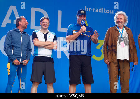 Bad Staffelstein, Deutschland. 28. Juli 2019. Entertainer Thomas Gottschalk (r-l), Markus Söder (CSU), Ministerpräsident des Freistaates Bayern, Hans Reichhart (CSU), Staatssekretär für Wohnungswesen, Bau und Verkehr, und Thorsten Glauber (Freie Wähler), Staatsminister für Umwelt und Verbraucherschutz wird auf der Bühne bei der Eröffnung des 30. BR Radtour. Credit: Peter Kolb/dpa/Alamy leben Nachrichten Stockfoto