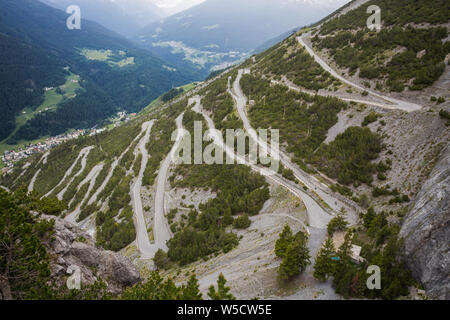 U-Form gebogene Straße in Richtung Türme von Fraele, eine touristische Attraktion im Norden von Valtellina, Italien. Stockfoto