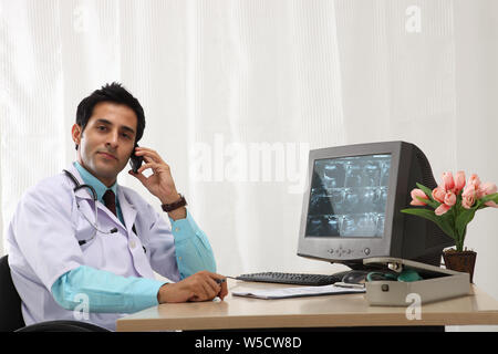 Männlicher Arzt Gespräch am Handy im Krankenhaus Stockfoto