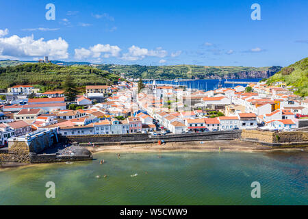 Idyllischen Strand Praia und azurblauen Bucht Baia do Porto Pim. Befestigungen, Mauern, Tore, roten Dächer der historischen touristischen Zentrum von Horta, Yachten in der Stockfoto