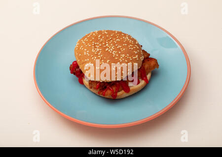 Vegane Wurst Sandwich mit Ketchup auf einem gesäten Bun auf einem blauen Platte Stockfoto