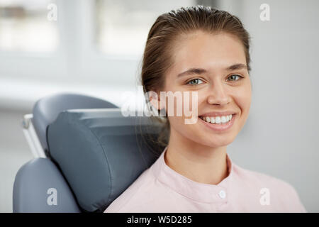 Kopf und Schultern Porträt der hübsche junge Frau in die Kamera lächelnd und mit perfekten weißen Zähne, kopieren Raum Stockfoto