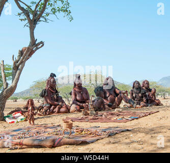 Himba Frauen verkaufen Kunsthandwerk und Schnickschnack für Touristen in ihr Dorf, Kaokoveld, Namibia, Afrika Stockfoto