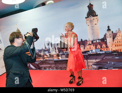 27 Juli 2019, Sachsen, Leipzig: Schauspieler Jan Josef Liefers Fotos seiner Frau Anna Loos mit einer professionellen Kamera eines Fotografen auf dem Teppich des GRK-Golf-Charity Masters Gala im Hotel The Westin Leipzig. Zum 12. Mal prominente sammeln Spenden für karitative Zwecke an der Non-profit-Turnier. Foto: Jens Kalaene/dpa-Zentralbild/dpa Stockfoto