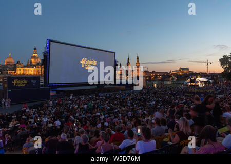 24 Juli 2019, Sachsen, Dresden: Zahlreiche Gäste der "Filmnächte am Elbufer" sitzen vor der Kulisse der Dresdner Altstadt mit der Kuppel des Kunstakedemie (L-R), der Frauenkirche, der hausmannsturm, der Hofkirche, der Semperoper und im Kino. Foto: Robert Michael/dpa-Zentralbild/dpa Stockfoto