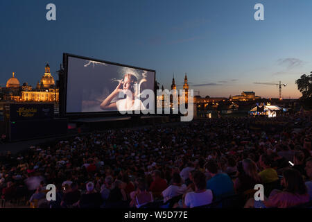 24 Juli 2019, Sachsen, Dresden: Zahlreiche Gäste der "Filmnächte am Elbufer" sitzen vor der Kulisse der Dresdner Altstadt mit der Kuppel des Kunstakedemie (L-R), der Frauenkirche, der hausmannsturm, der Hofkirche, der Semperoper und im Kino. Foto: Robert Michael/dpa-Zentralbild/dpa Stockfoto