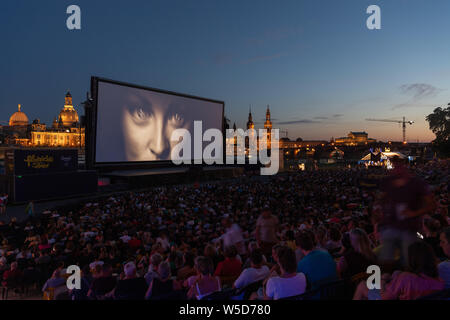 24 Juli 2019, Sachsen, Dresden: Zahlreiche Gäste der "Filmnächte am Elbufer" sitzen vor der Kulisse der Dresdner Altstadt mit der Kuppel des Kunstakedemie (L-R), der Frauenkirche, der hausmannsturm, der Hofkirche, der Semperoper und im Kino. Foto: Robert Michael/dpa-Zentralbild/dpa Stockfoto