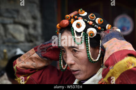 (190728) - LHASA, Juli 28, 2019 (Xinhua) - eine Frau setzt auf burang Kleidung in der Grafschaft Burang von Ali, der Südwesten Chinas Autonomen Region Tibet, 22. Juli 2019. Burang, traditionelle Kleidung tragen in der Grafschaft Burang von Ali, hat eine Geschichte von mehr als 1.000 Jahren. Ein Anzug kann über 25 kg wiegen, weil es mit Gold, Silber, Perlen und andere Schmuckstücke dekoriert ist. (Xinhua / Chogo) Stockfoto