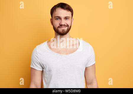 Fröhlicher junger gerissen Schönen in der Großen Geist, Aktien Eindrücke, positive Emotionen zum Ausdruck bringt. bis Foto schliessen. Isolierte gelben Hintergrund. Stockfoto