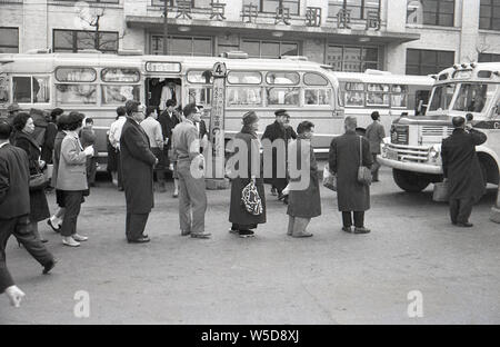 [1960s Japan - Tokyo Bus Station] - Menschen Schlange am Busbahnhof mit Motorhaube Busse vor Tokyo Central Post Office in Marunouchi, Tokio, 1960 (Showa 35). Stockfoto